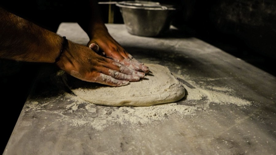 Pizzateig wird von Hand geknetet