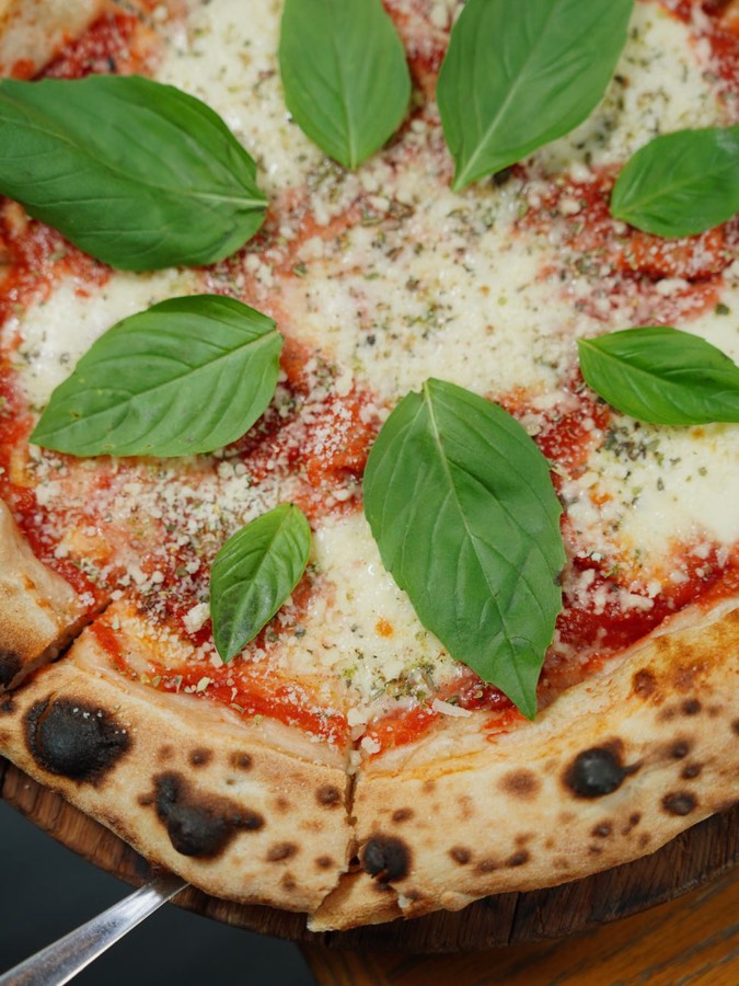 Pizza mit Tomatensoße, Käse und frischem Basilikum
